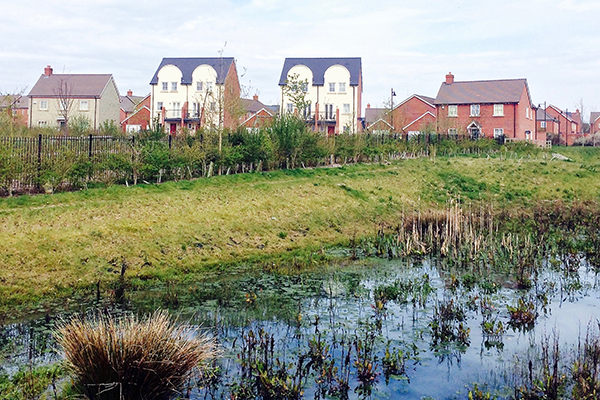 View of a suds pond in front of new housing development