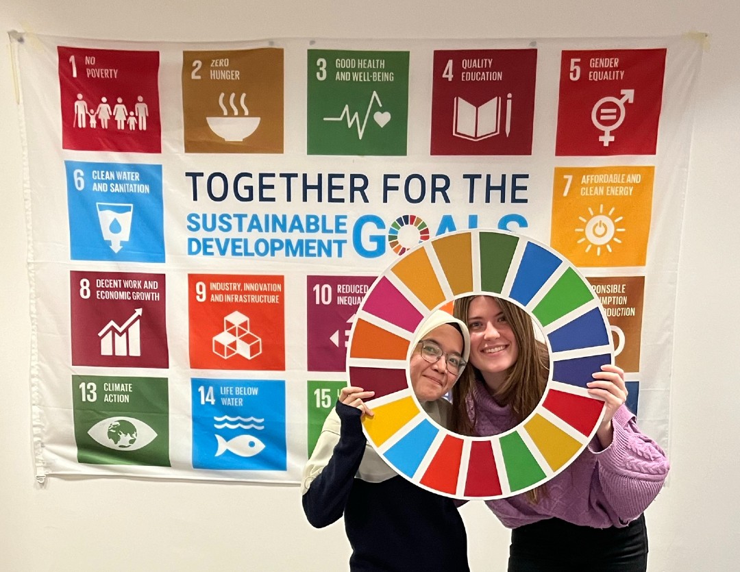 HR Wallingford young members of staff pausing in front of UN Sustainable goals banner