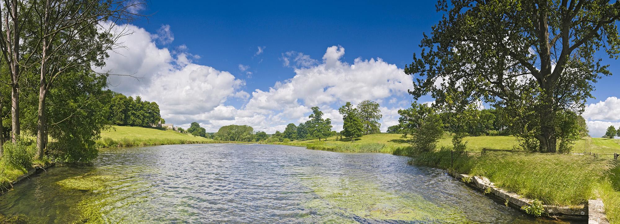 View of wide freshwater river with green river banks