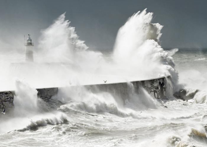 view of waves crashing against a lighthouse