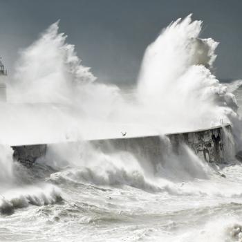 view of waves crashing against a lighthouse